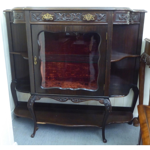 212 - A late Victorian mahogany display cabinet with a glazed door, flanked by open shelves, raised on cab... 