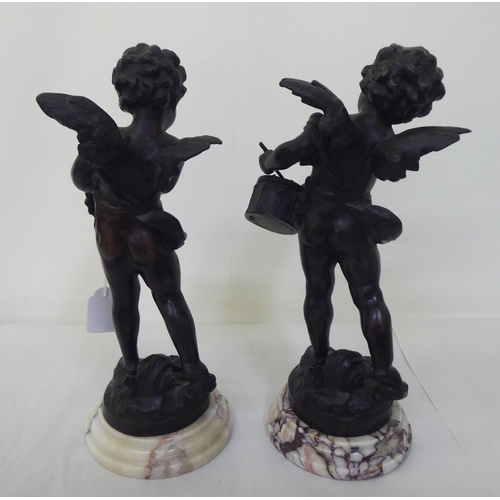 223 - A pair of bronze cherubic figures, posing with instruments, each raised on a marble plinth  bears in... 