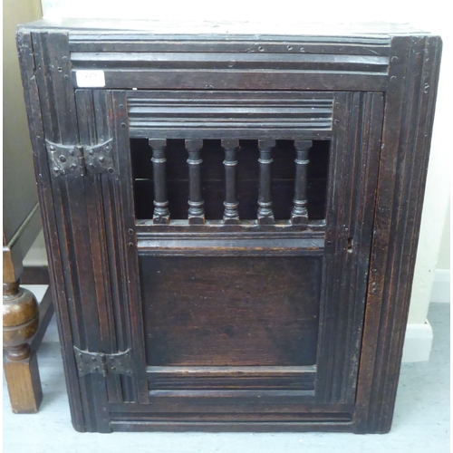 229 - A late 18thC oak wall hanging food cabinet with a single door  29