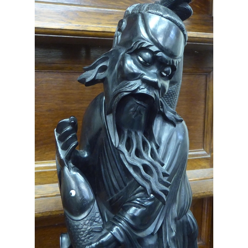 234 - A Japanese carved and lacquered wooden figure, depicting a triumphant fisherman  22