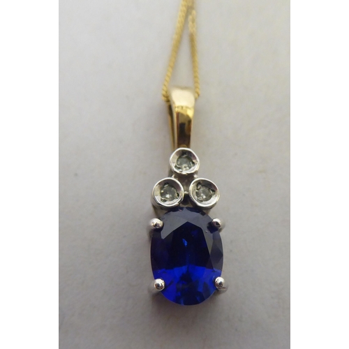 250 - A claw set blue stone and diamond 9ct bi-coloured gold pendant, on a fine neckchain