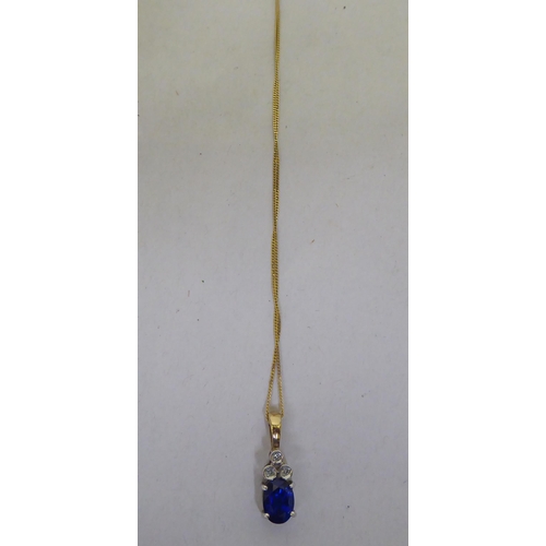 250 - A claw set blue stone and diamond 9ct bi-coloured gold pendant, on a fine neckchain