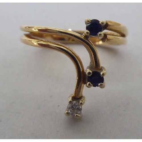 269 - A yellow metal ring, claw set with two sapphires and one diamond  stamped 585