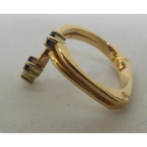 269 - A yellow metal ring, claw set with two sapphires and one diamond  stamped 585