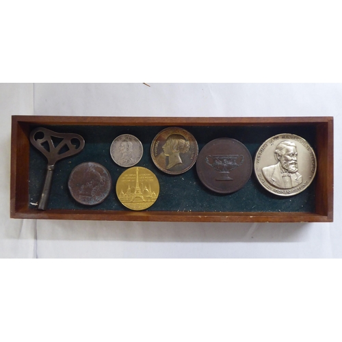 27 - An uncollated collection of British and foreign coins, plaques and medallions, in a table-top displa... 