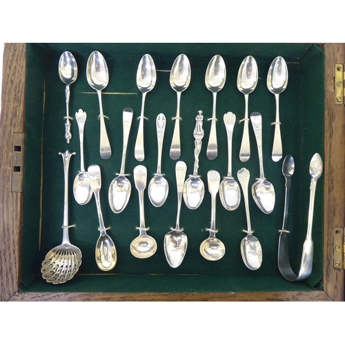 308 - A presentation case with a deep set, glazed oak door, containing silver teaspoons