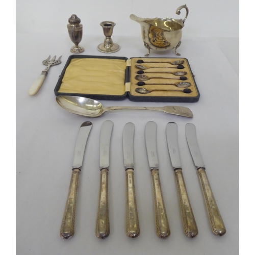 309 - Silver collectables: to include butter knives with loaded handles; a sauce boat and dwarf candlestic... 