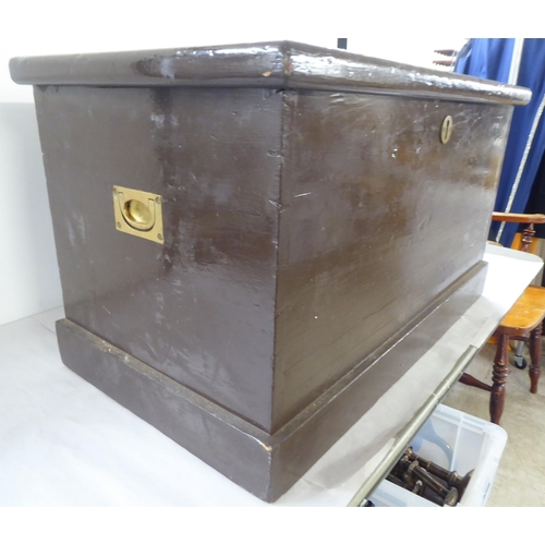 46 - A mid 20thC brown painted pine box with a lockable, hinged lid and opposing recessed brass handles&n... 