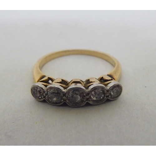 78 - A yellow metal ring, set with a row of diamonds