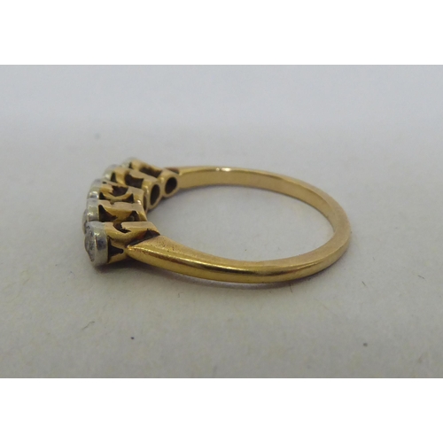 78 - A yellow metal ring, set with a row of diamonds