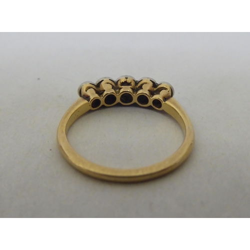 78 - A yellow metal ring, set with a row of diamonds