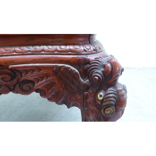 96 - A 20thC Sino-European red stained and profusely carved round back chair, featuring entwined dragons,... 