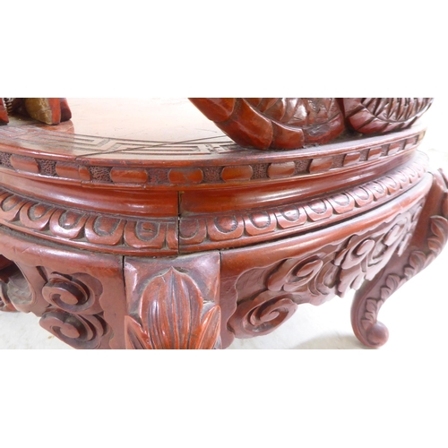 96 - A 20thC Sino-European red stained and profusely carved round back chair, featuring entwined dragons,... 