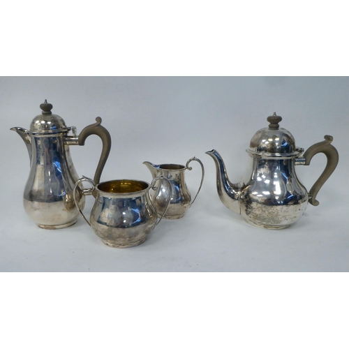 1 - A four piece silver pear shape tea set, comprising a teapot and hot water pot with carved wooden han... 