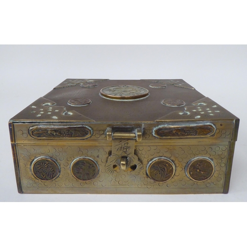 131 - A Chinese brass casket with engraved decoration, mounts, applied medallions and a carved jade tablet... 