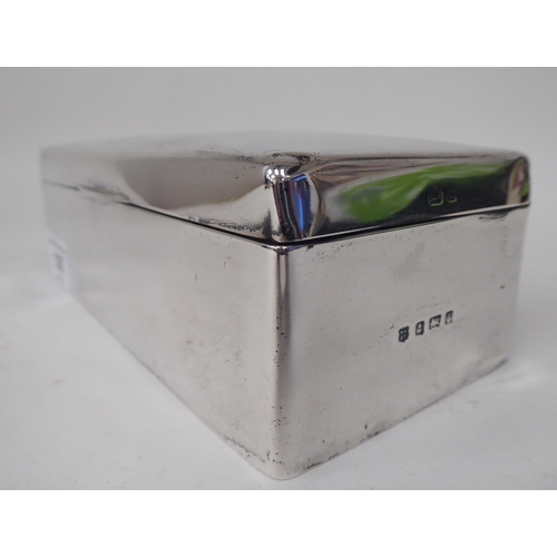 135 - An Edwardian silver cigarette box with straight sides and a hinged lid, enclosing a cedar lined inte... 