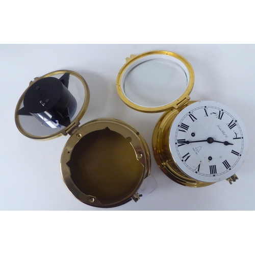 136 - A modern London Clock Co lacquered brass cased bulkhead timepiece; faced by a printed Roman dial; an... 