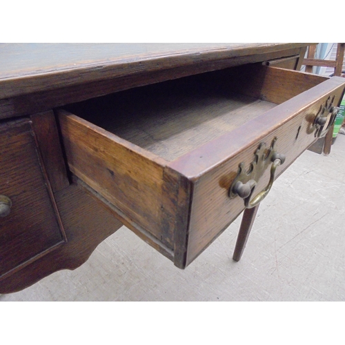 137 - A 19thC country made carved oak lowboy with a planked top, over one central and two flank box drawer... 