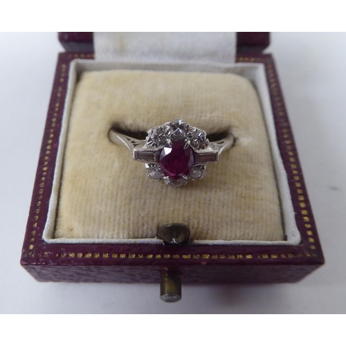 139 - A white metal, claw set ruby and diamond cluster ring