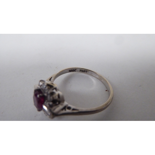 139 - A white metal, claw set ruby and diamond cluster ring