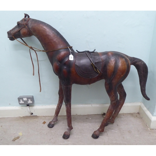 147 - A burnished and moulded hide standing, saddled and bridled model horse  approx. 37