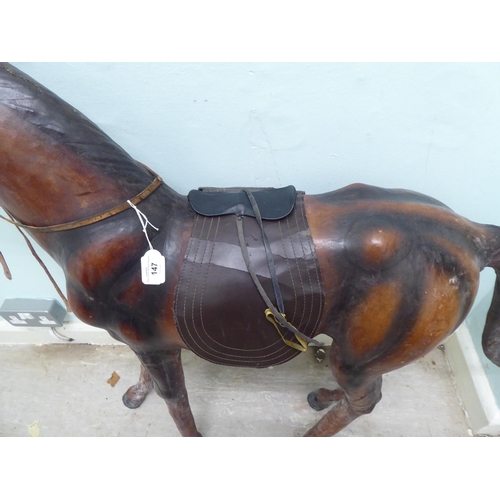 147 - A burnished and moulded hide standing, saddled and bridled model horse  approx. 37