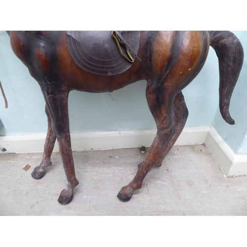 147 - A burnished and moulded hide standing, saddled and bridled model horse  approx. 37