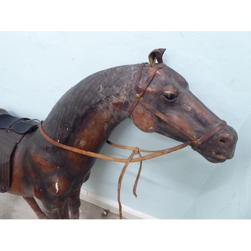 147 - A burnished and moulded hide standing, saddled and bridled model horse  approx. 37