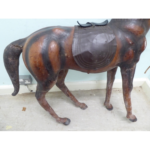 147 - A burnished and moulded hide standing, saddled and bridled model horse  approx. 37