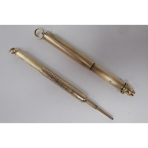 159 - Two similar yellow metal cased propelling pencils, on pendant rings