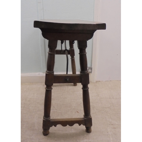 166 - A 19thC Spanish rustically constructed walnut serving table, the planked top raised on splayed, ring... 