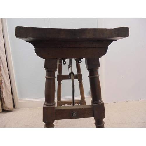 166 - A 19thC Spanish rustically constructed walnut serving table, the planked top raised on splayed, ring... 