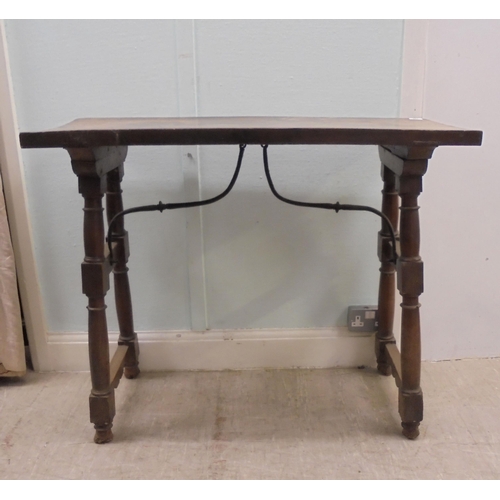 166 - A 19thC Spanish rustically constructed walnut serving table, the planked top raised on splayed, ring... 