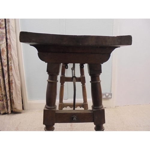 166 - A 19thC Spanish rustically constructed walnut serving table, the planked top raised on splayed, ring... 