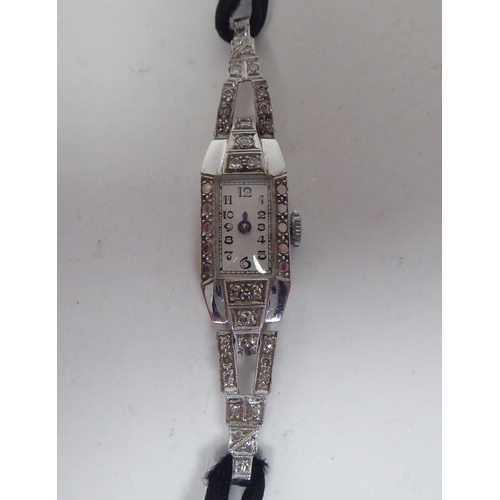 167 - A lady's 1920s diamond encrusted, platinum cased cocktail watch, on a flexible black cord strap, fac... 