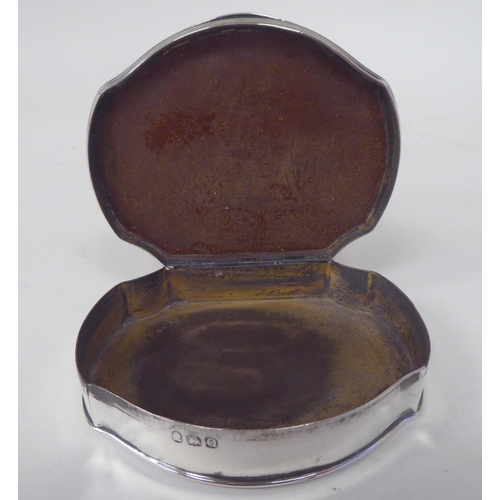 169 - A George III silver snuff box with applied wire borders, the hinged lid set with a speckled gilt and... 