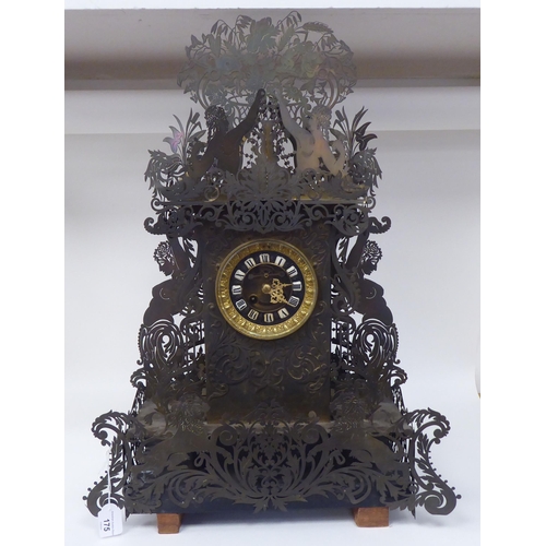 175 - A Continental fretworked brass cased mantel clock, featuring nude term figures, heraldic lions, flor... 