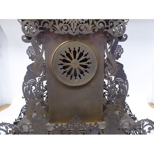 175 - A Continental fretworked brass cased mantel clock, featuring nude term figures, heraldic lions, flor... 