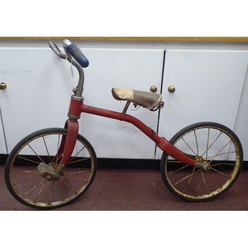 182 - A child's vintage Tri-ang bicycle with a red painted frame and downswept handlebars, the pedals fitt... 