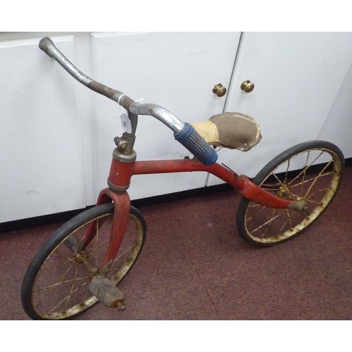 182 - A child's vintage Tri-ang bicycle with a red painted frame and downswept handlebars, the pedals fitt... 