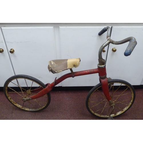 182 - A child's vintage Tri-ang bicycle with a red painted frame and downswept handlebars, the pedals fitt... 