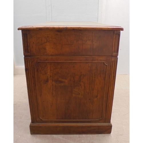 185 - An early 20thC satin mahogany nine drawer, twin pedestal desk with a green hide scriber and brass ba... 