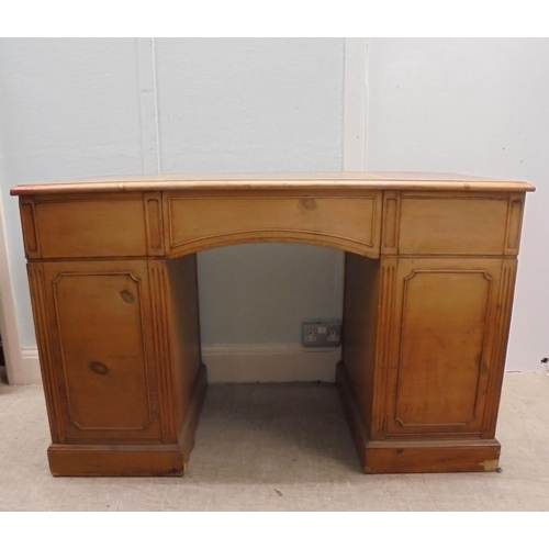 185 - An early 20thC satin mahogany nine drawer, twin pedestal desk with a green hide scriber and brass ba... 