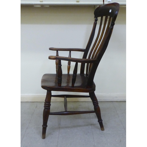 2 - A late Victorian beech and elm framed Windsor chair with a splat back, open arms and solid seat, rai... 