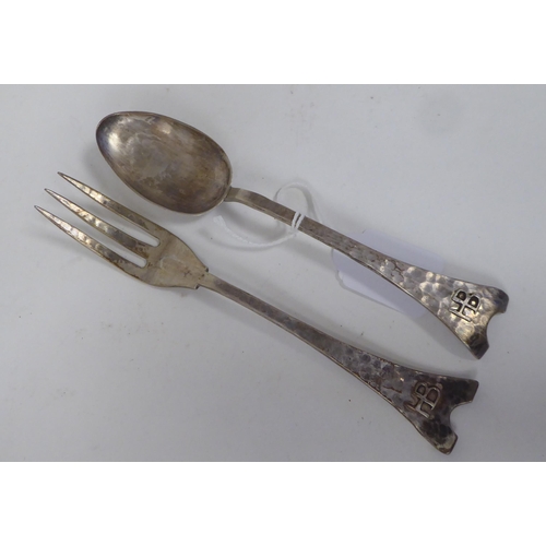 206 - An Arts & Crafts spot-hammered silver presentation dessert spoon and fork  bearing initials on t... 