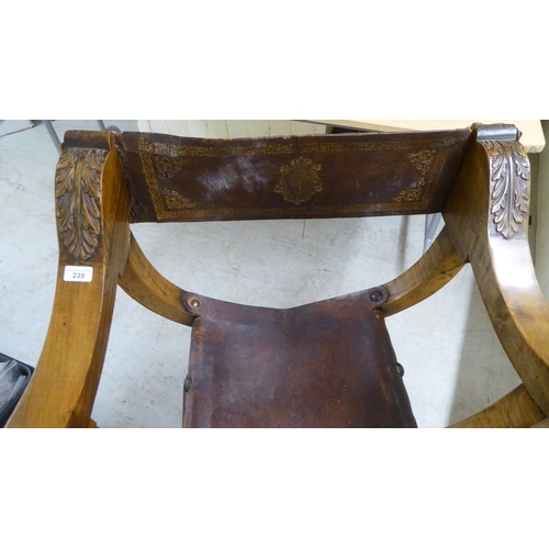 239 - A late 19th/early 20thC Southern European walnut framed Savonarola design chair with rosette and aca... 