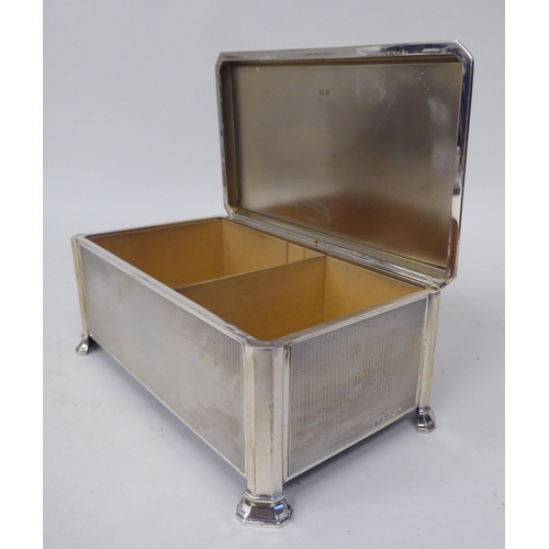 246 - A silver engine turned cigarette box with chamfered corners, straight sides and a hinged lid, enclos... 