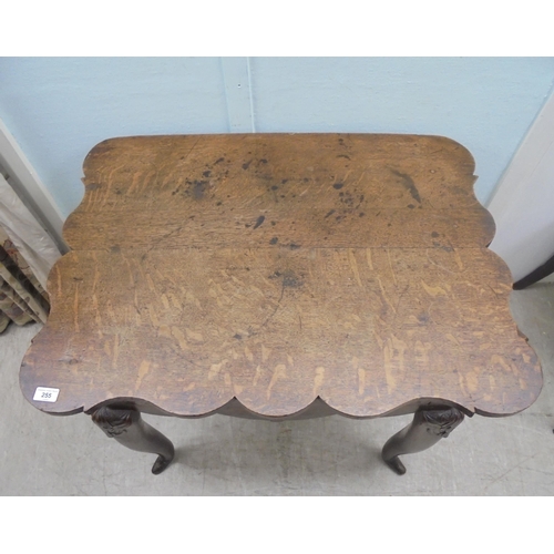 255 - An early 18thC possibly Irish oak lowboy, the planked top with a shaped border and apron, incorporat... 