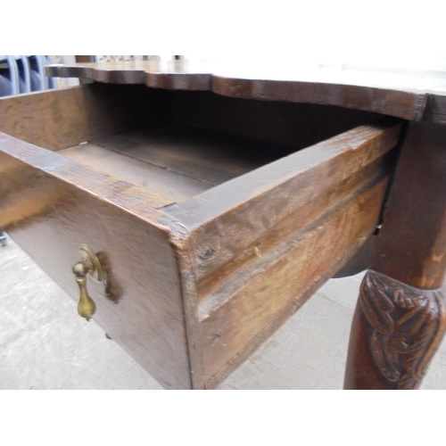 255 - An early 18thC possibly Irish oak lowboy, the planked top with a shaped border and apron, incorporat... 