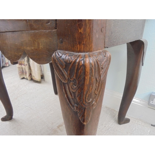 255 - An early 18thC possibly Irish oak lowboy, the planked top with a shaped border and apron, incorporat... 